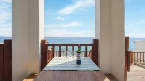a bottle of wine on a table on a balcony at Youngduk Sea & Spa Pension in Yeongdeok