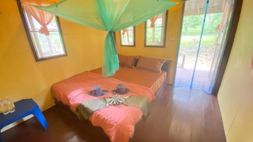 a bedroom with two beds in a room with windows at Eco Bungalow in Ko Phayam