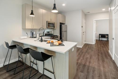 a kitchen with a counter and stools in a room at Luxury Furnished Apartments by Hyatus Downtown at Yale in New Haven
