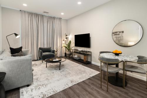 a living room with a couch and a table and a mirror at Luxury Furnished Apartments by Hyatus Downtown at Yale in New Haven