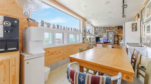 a kitchen with a wooden table and a large window at Namhae baramundeok Pension in Namhae