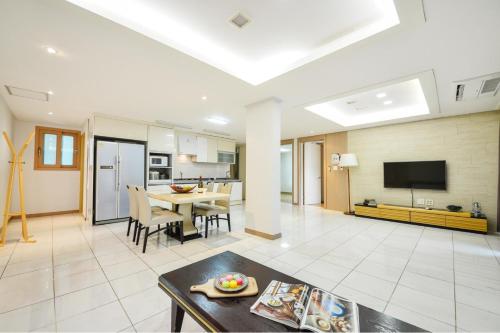 a large living room with a table and a tv at Gapyeong Club Fish Villas Pension in Gapyeong