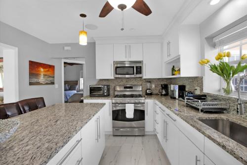 a kitchen with white cabinets and granite counter tops at Luxury Water Front, Heated Pool & Jacuzzi, 5bdrm in Pompano Beach