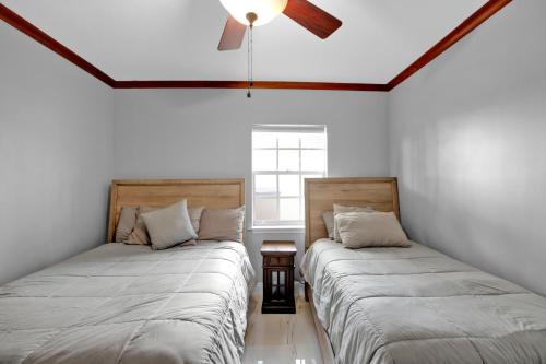 two beds sitting next to each other in a room at Luxury Water Front, Heated Pool & Jacuzzi, 5bdrm in Pompano Beach