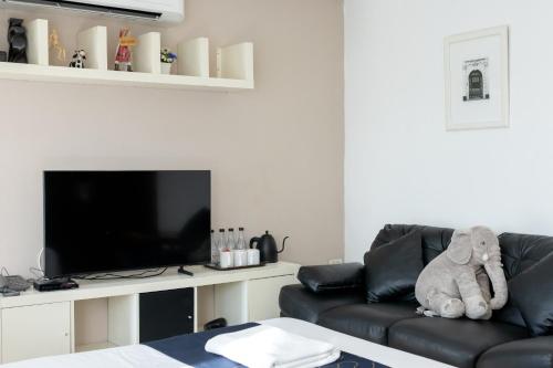 a living room with a couch and a flat screen tv at Nature Boutique Residence in Bangkok