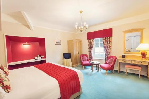 a bedroom with a bed and a desk and chairs at Briery Wood Hotel in Ambleside