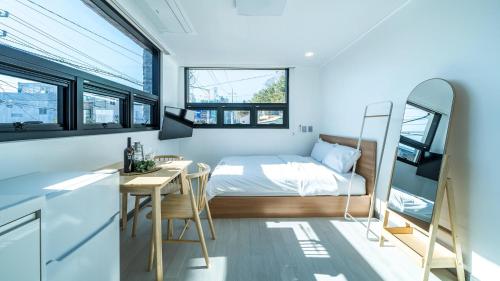 ein kleines Schlafzimmer mit einem Bett und einem Tisch und Stühlen in der Unterkunft Yeosu Nangmanstay pension in Yeosu