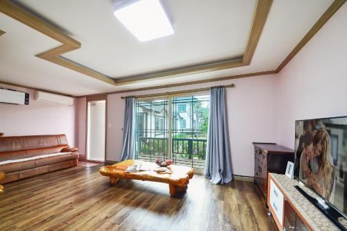 a living room with a couch and a table at Samcheok Herb Pension in Samcheok