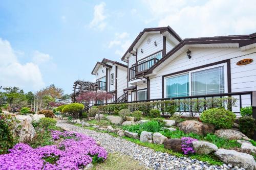 a house with a garden in front of it at Samcheok Herb Pension in Samcheok