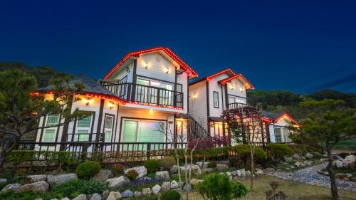 a large house with lights on it at night at Samcheok Herb Pension in Samcheok