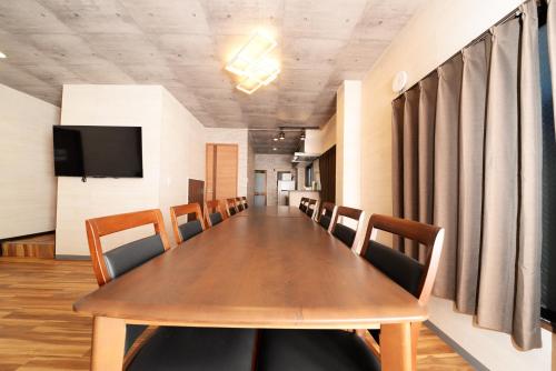a conference room with a long wooden table and chairs at ACTResidence第二 4室1バスルーム1シャワー3トイレ in Tokyo
