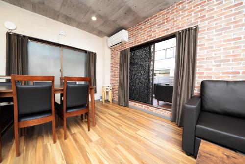 a dining room with a brick wall and a table and chairs at ACTResidence第二 4室1バスルーム1シャワー3トイレ in Tokyo