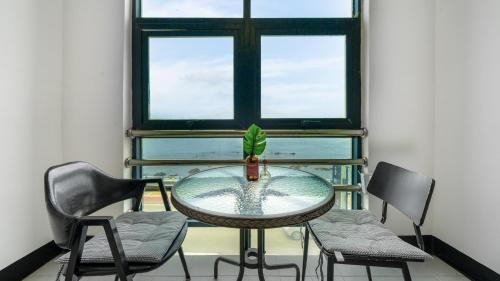 a table and chairs in a room with a window at Donghae donghaeleulkeulida Pension in Donghae