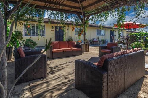 a patio with couches and chairs under a pergola at Giraffe House in Chula Vista