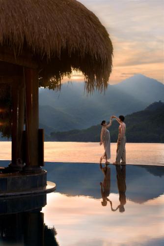 two people dancing on the water at a resort at Mai Chau Hideaway Lake Resort in Mai Chau