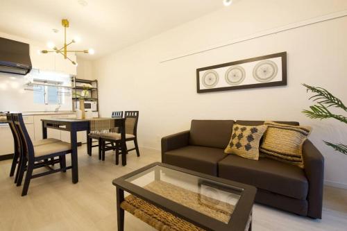 a living room with a couch and a table at Li Kotohogi 302 in Naha