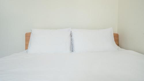 two white pillows sitting on top of a bed at Samcheok jangho sanho Pension in Samcheok
