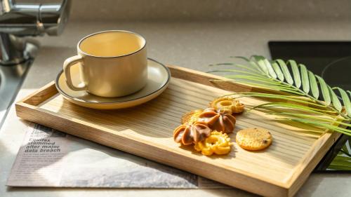 a cup of coffee and cookies on a wooden tray at Samcheok jangho sanho Pension in Samcheok