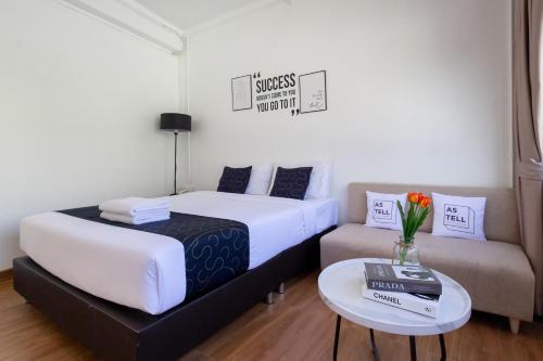 a hotel room with a bed and a couch at Nature Boutique Residence in Bangkok