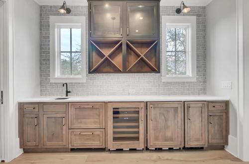a kitchen with wooden cabinets and two windows at 3108 Palm by AvantStay Oceanfront Private Pool Incredible Views in Isle of Palms
