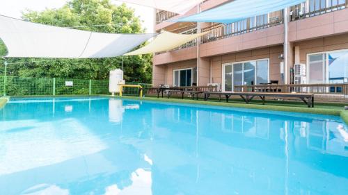 a swimming pool in front of a building at yeosu moranggee pension in Yeosu