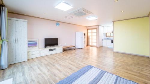 an empty living room with a flat screen tv at yeosu moranggee pension in Yeosu