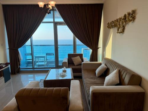 a living room with couches and a view of the ocean at Ajman Luxurious Holiday Homes in Ajman 
