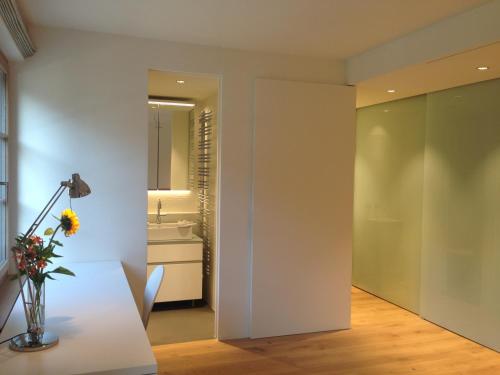 a living room with a table and a mirror at Carouge Loft Apartment in Geneva