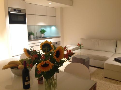 a living room with a vase of sunflowers on a table at Carouge Loft Apartment in Geneva