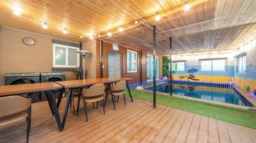 a house with a swimming pool and a table and chairs at Cheongdo Ellago Poolvilla Pension in Cheongdo