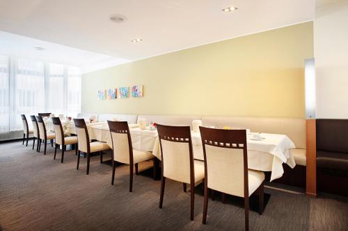 una sala da pranzo con un lungo tavolo e sedie di Hotel am Jakobsmarkt a Norimberga