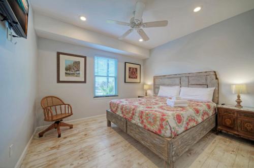 a bedroom with a bed and a ceiling fan at 6BDR Balcony w Bay View Shared Pool Boat Dock Keeper Red by AvantStay in Padre Island