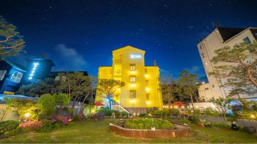 a yellow building in the middle of a city at night at Gapyeong Rowa River view Pension in Gapyeong
