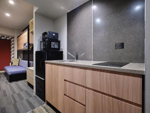 una cucina con un bancone con un lavello e un frigorifero di MONday Apart Hamamatsucho Daimon a Tokyo