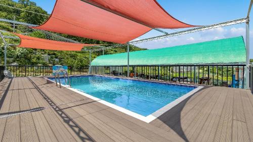 a swimming pool under a canopy on a wooden deck at Ganghwa Herb Pension in Incheon