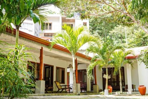 a house with palm trees in front of it at Hiri Point Villa in Dickwella