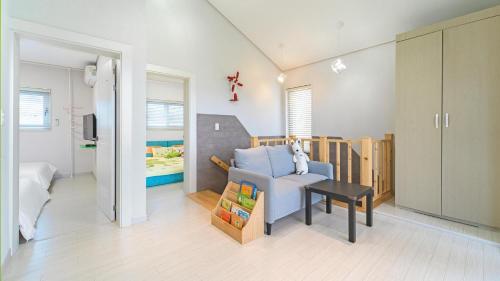 a living room with a blue couch and a table at Gyeongju cheongun28 kids Poolvilla in Gyeongju