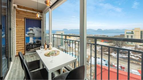 東海市にあるDonghae Hill Stay Pensionの海の景色を望むバルコニー(テーブル、椅子付)