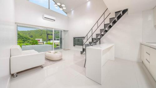 een witte badkamer met een trap en een groot raam bij Gapyeong Shiny Pension in Gapyeong