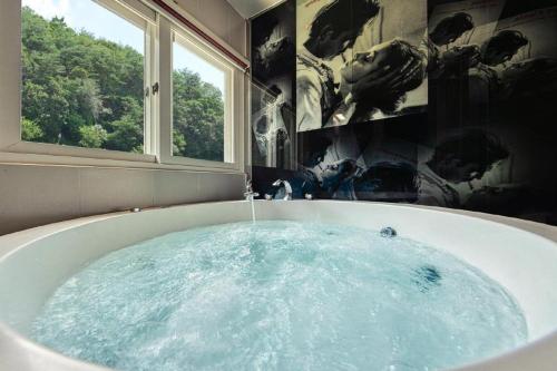a bath tub with water in it in a bathroom at Gapyeong Pogny Kids Poolvilla in Gapyeong