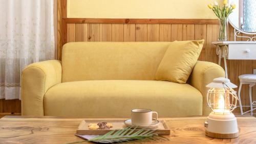 a yellow couch in a living room with a table at Yangpyeong Smile Caravan Pension in Yangpyeong