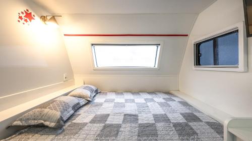 ein kleines Zimmer mit einem Bett und einem Fenster in der Unterkunft Yangpyeong Smile Caravan Pension in Yangpyeong