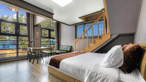 a hotel room with a bed and a staircase at Samcheok Lamer Pension in Samcheok
