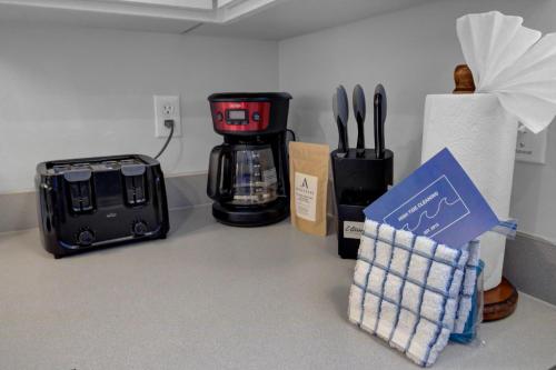a kitchen counter with a coffee maker and utensils at Ion by AvantStay Walk to Beach Dining Shopping Central Location Deck in Sullivans Island