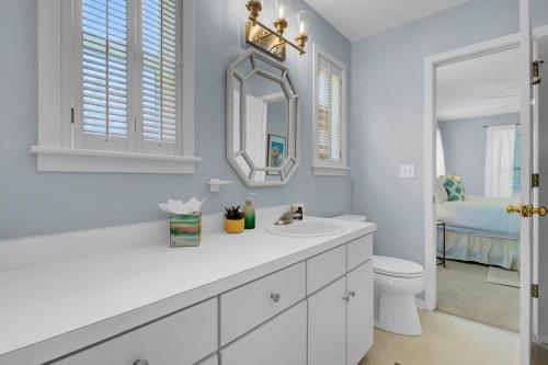 a white bathroom with a sink and a mirror at Ion by AvantStay Walk to Beach Dining Shopping Central Location Deck in Sullivans Island