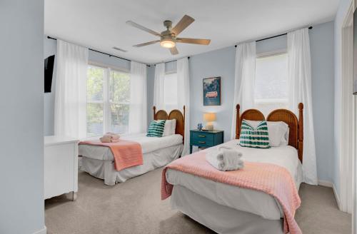 a bedroom with two beds and a ceiling fan at Ion by AvantStay Walk to Beach Dining Shopping Central Location Deck in Sullivans Island