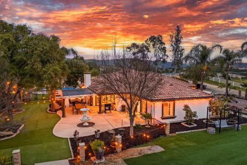 an aerial view of a house with a sunset at Breathtaking Meadows by AvantStay Temecula Group Retreat Pool Pickleball Firepit Hot Tub in Temecula