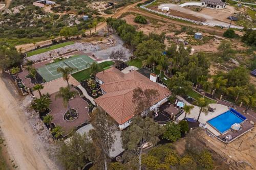 an overhead view of a house with a tennis court and a tennis court at Breathtaking Meadows by AvantStay Temecula Group Retreat Pool Pickleball Firepit Hot Tub in Temecula