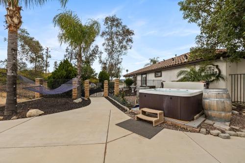 a hot tub in a yard next to a house at Breathtaking Meadows by AvantStay Temecula Group Retreat Pool Pickleball Firepit Hot Tub in Temecula