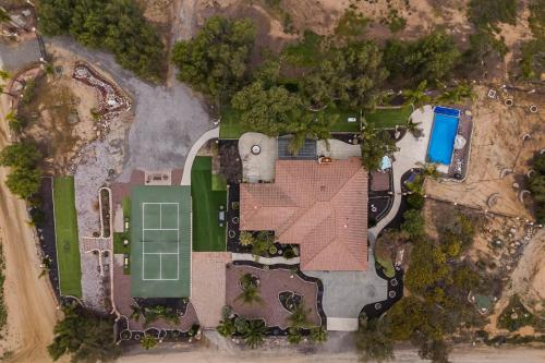 an aerial view of a yard with a tennis court and a house at Breathtaking Meadows by AvantStay Temecula Group Retreat Pool Pickleball Firepit Hot Tub in Temecula